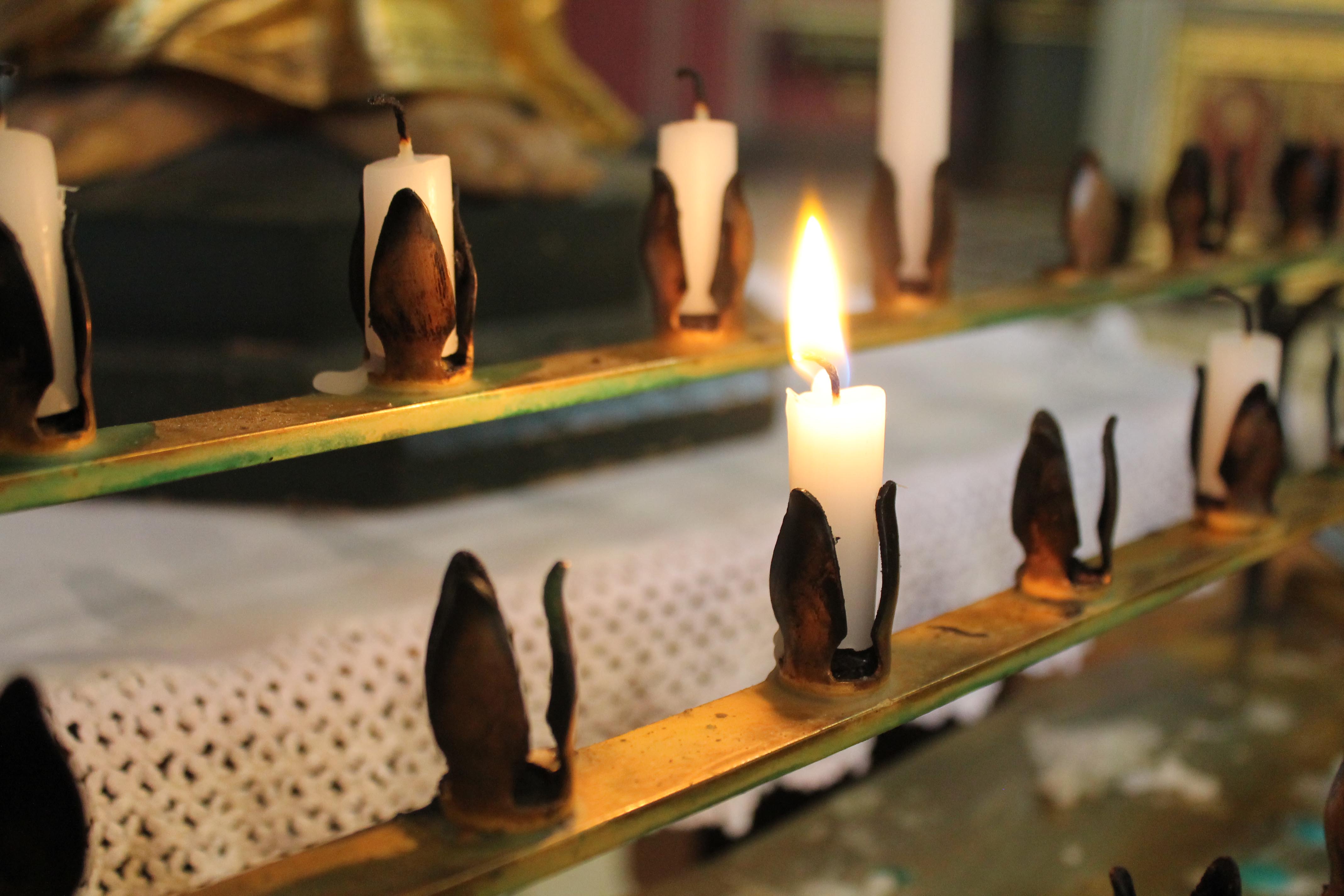 Lit Candle in a row - Church of England stock photo